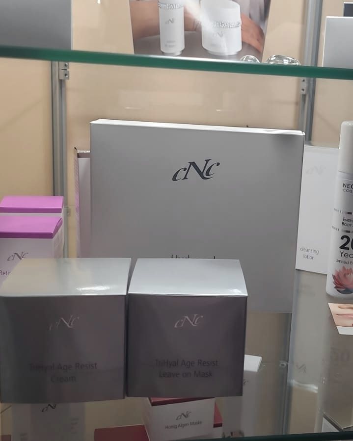 Pflegeprodukte von CNC Skincare in einer Glasvitrine