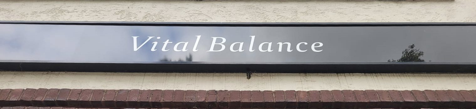 Ladenschild mit dem Schriftzug Vital Balance über dem Schaufenster
